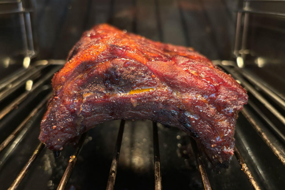 <p>Baby back ribs sitting on a rack inside of the GE Profile Smart Indoor Smoker.</p>
