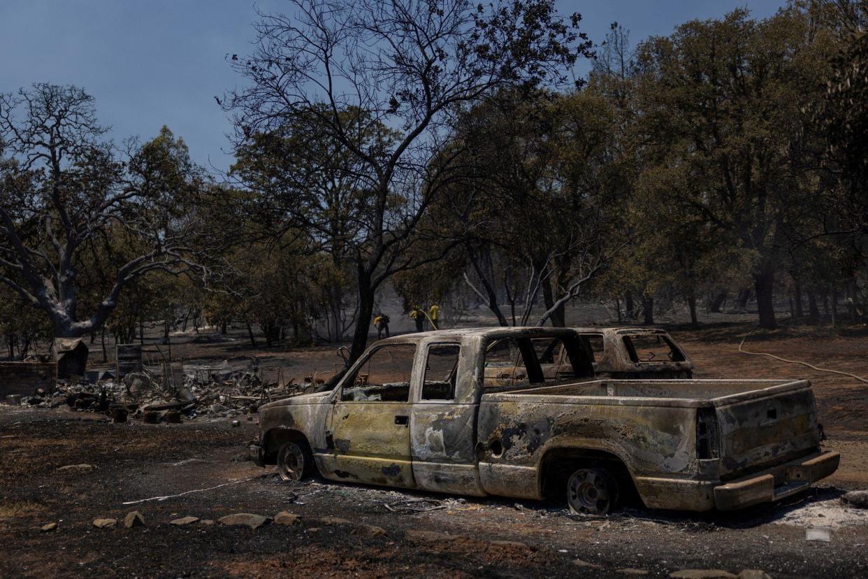 Firefighters work near burned vehicles in Oroville, California 