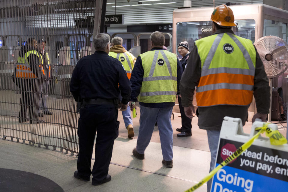 Chicago Transit Authority employees work the scene where a Chicago Transit Authority derailed at the O'Hare Airport station early Monday, March 24, 2014, in Chicago. More than 30 people were injured after the eight-car train plowed across a platform and scaled an escalator at the underground station. (AP Photo/Andrew A. Nelles)