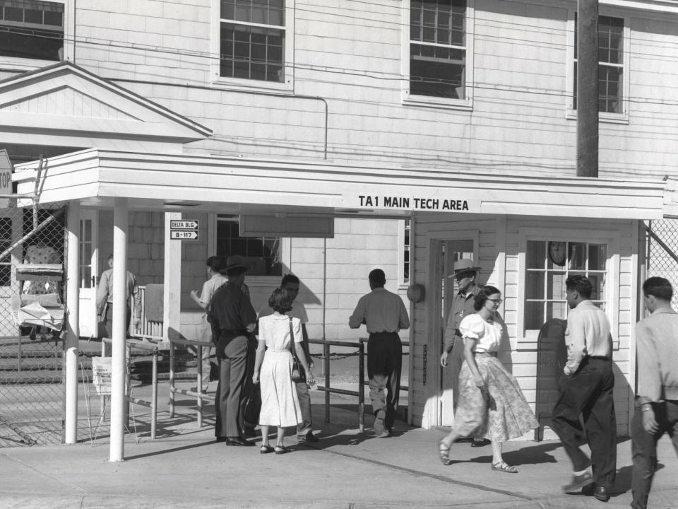 Several people enter and exist the entrance to the technical area at Los Alamos in 1951