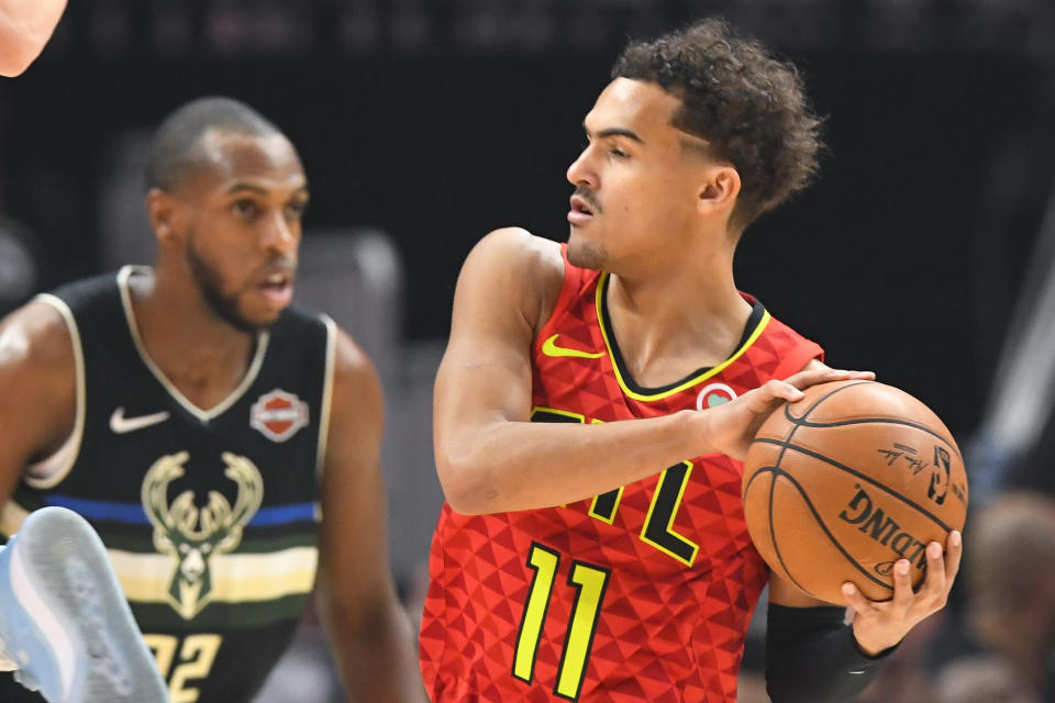 Atlanta Hawks guard Trae Young (11) looks over the floor as Milwaukee Bucks forward Khris Middleton defends during the first half of an NBA basketball game Friday, Dec. 27, 2019, in Atlanta. (AP Photo/John Amis)