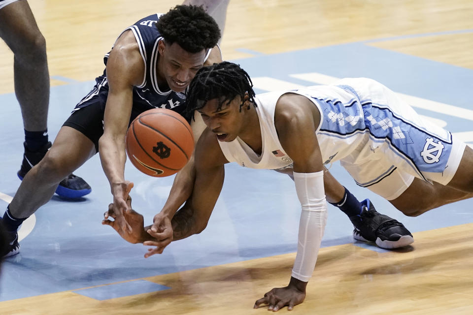 Duke forward Wendell Moore Jr. and North Carolina guard Caleb Love, right, struggle for a loose ball during the first half of an NCAA college basketball game in Chapel Hill, N.C., Saturday, March 6, 2021. (AP Photo/Gerry Broome)