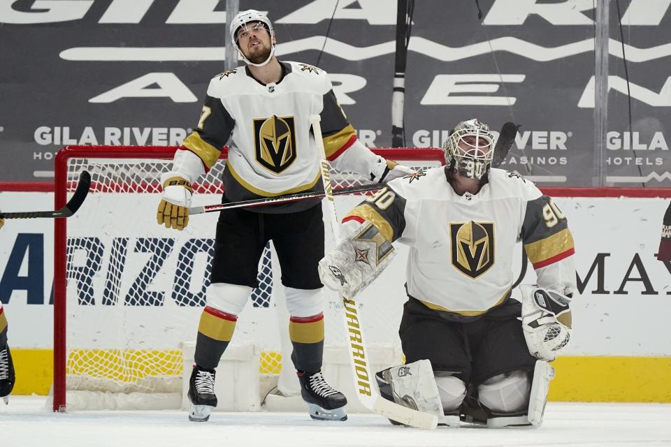 Vegas Golden Knights goaltender Robin Lehner (90) and defenseman Shea Theodore, left, pause on the ice after a goal was scored by Arizona Coyotes' Nick Schmaltz during the second period of an NHL hockey game Friday, Jan. 22, 2021, in Glendale, Ariz. (AP Photo/Ross D. Franklin)