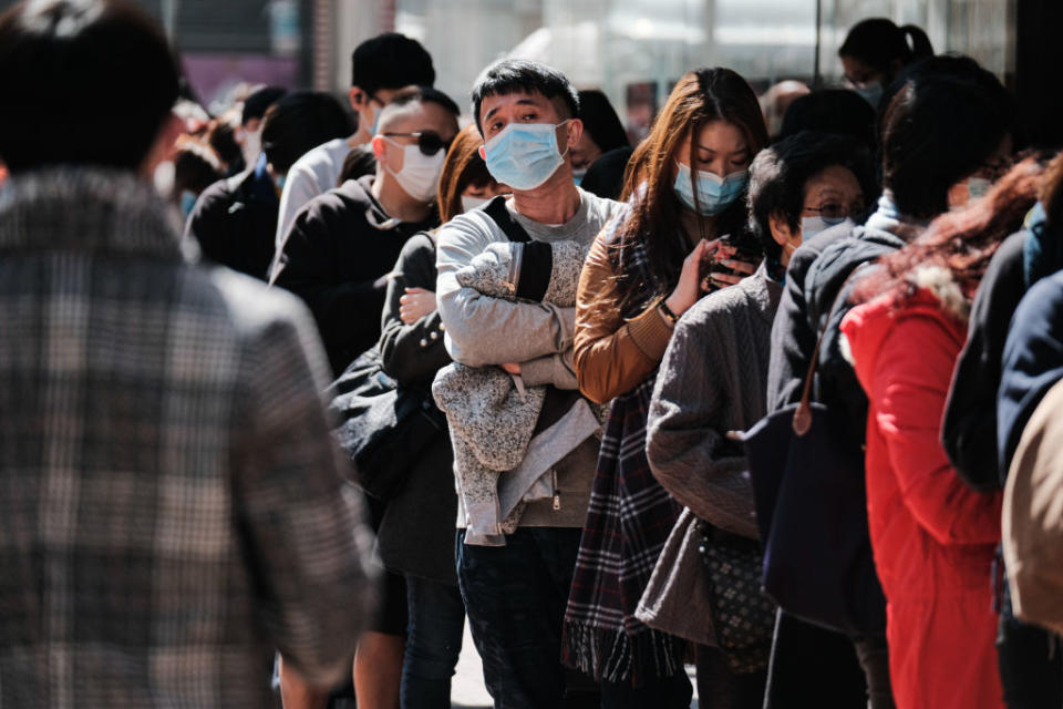 The spread of the virus can happen through sneezing and coughing in the street. Pictured is Hong Kong residents queueing to purchase face masks. Source: Getty