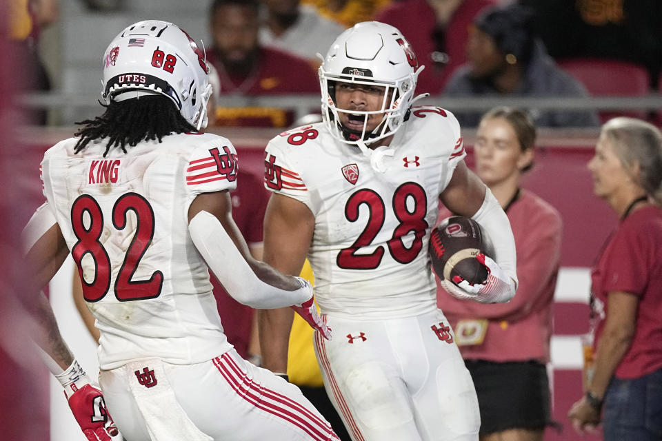 Utah safety Sione Vaki, right, celebrates his touchdown with Landen King during the second half of an NCAA college football game against Southern California Saturday, Oct. 21, 2023, in Los Angeles. (AP Photo/Mark J. Terrill)