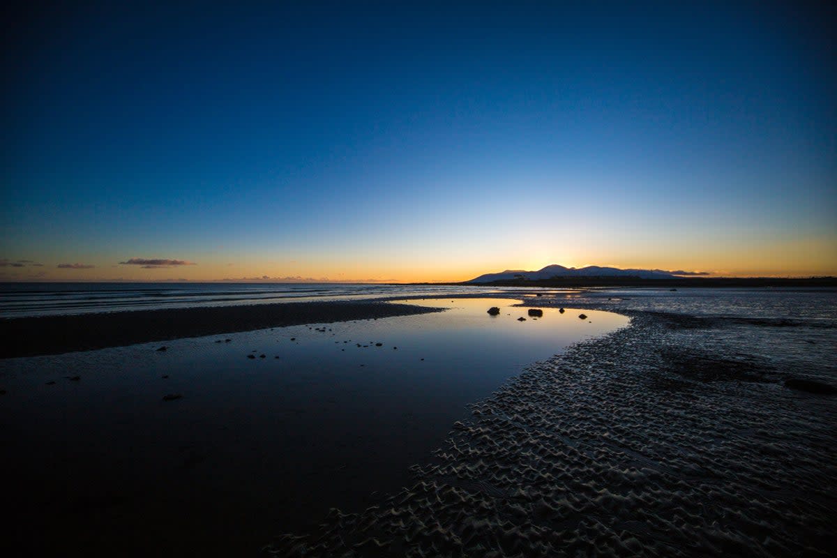 Tyrella Beach at sunset, with the Mourne Mountains in the background (Getty Images/iStockphoto)