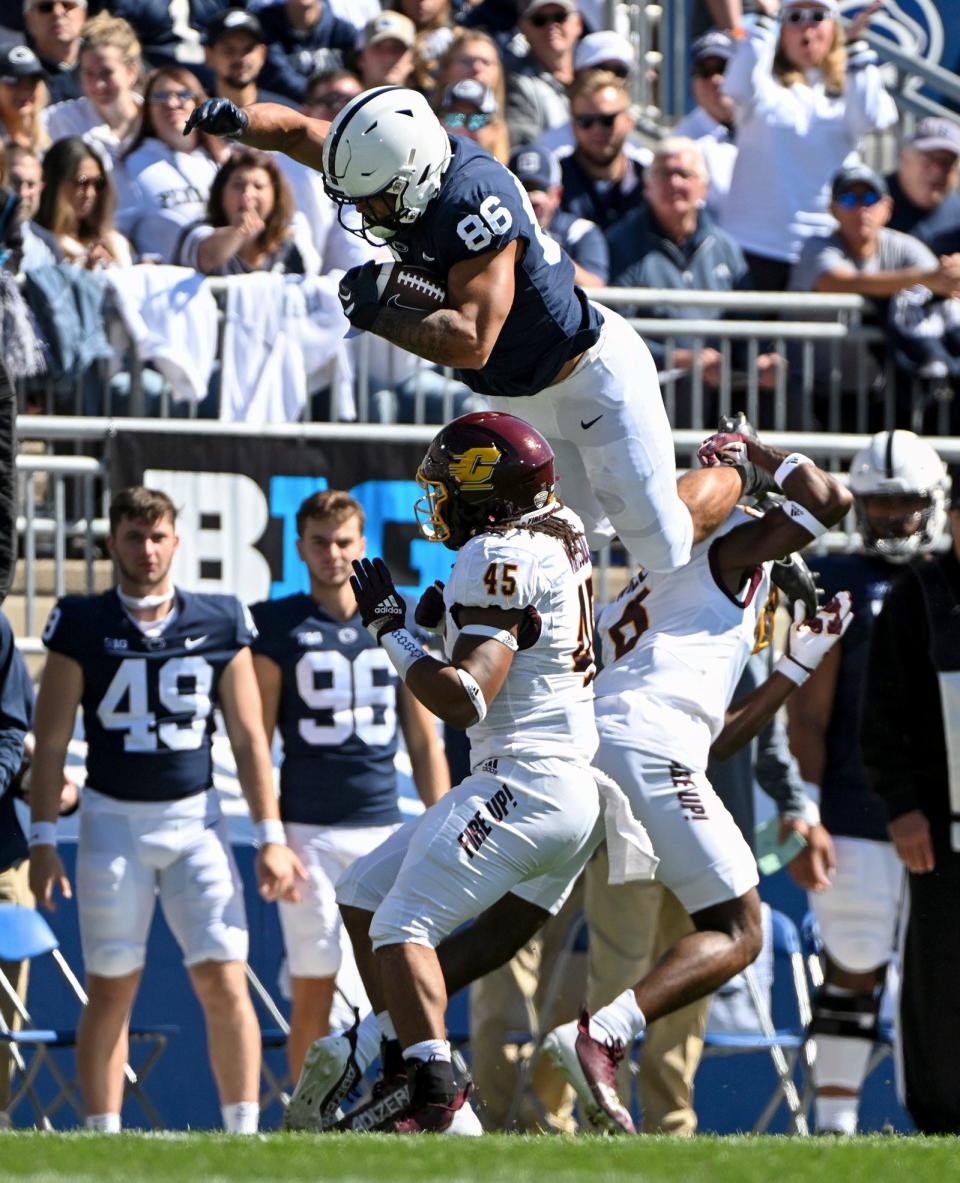 Penn State tight end Brenton Strange (86) hurdles Central Michigan defenders Lavario Wiley (6) and Justin Whiteside (45) during the first half of an NCAA college football game, Saturday, Sept. 24, 2022, in State College, Pa. (AP Photo/Barry Reeger)