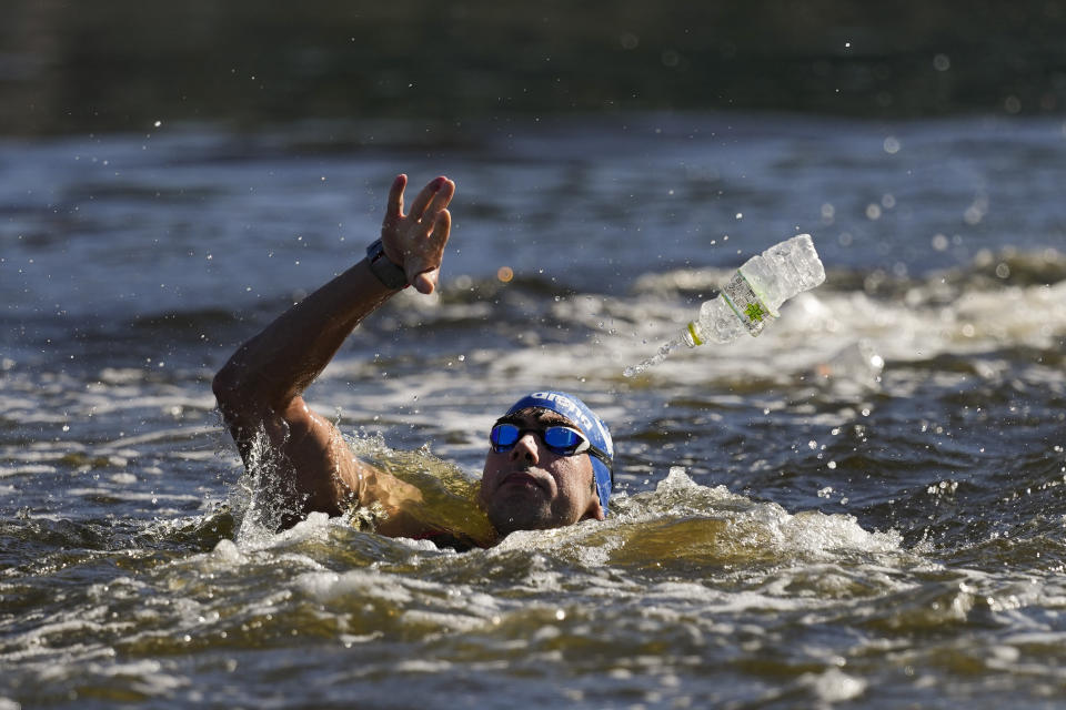 Athanasios Kynigakis, of Greece, tosses his battle at a feeding station during the men's marathon swimming event at the 2020 Summer Olympics, Thursday, Aug. 5, 2021, in Tokyo, Japan. (AP Photo/Jae C. Hong)