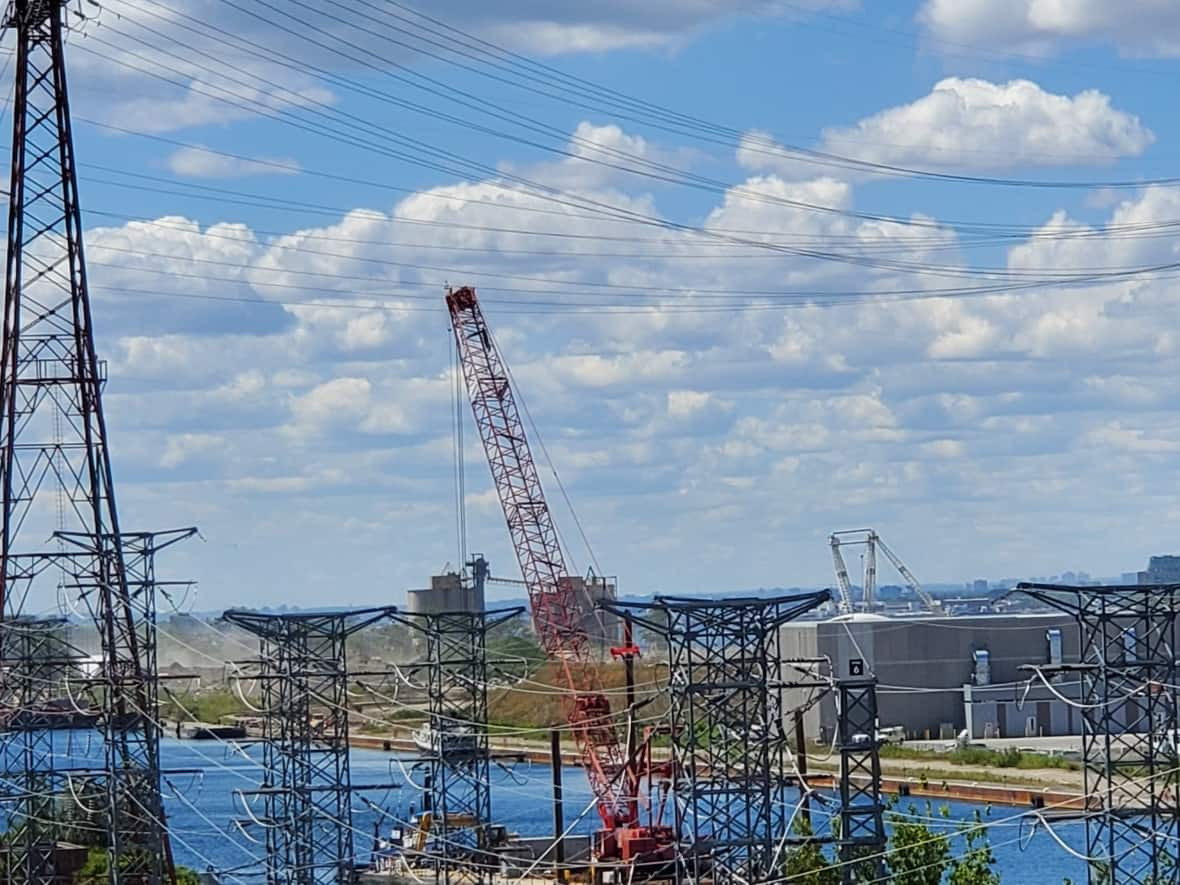 Hydro One shared this image of the crane - which was being transported by barge through the Port Lands - that is thought to have caused the outage when it hit high-voltage power lines.  (Hydro One/Twitter - image credit)