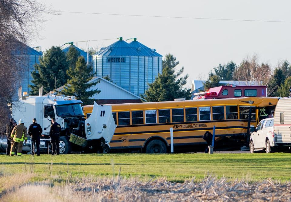 An officer from the Ontario Provincial Police (OPP) stands inside of a school bus as they work the scene of a motor vehicle crash involving a school bus and truck in the Township of Russell, Ont., Monday, April 22, 2024. 