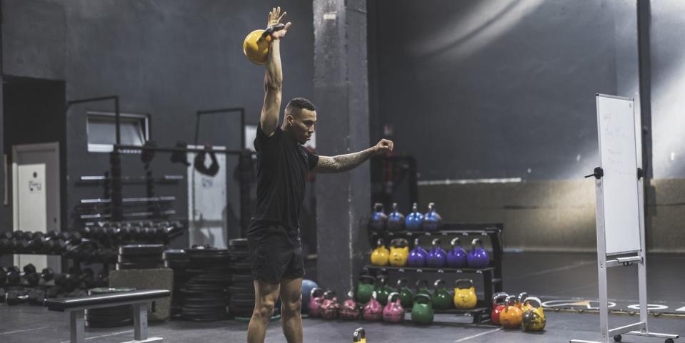 hispanic man lifting kettlebell in a gym