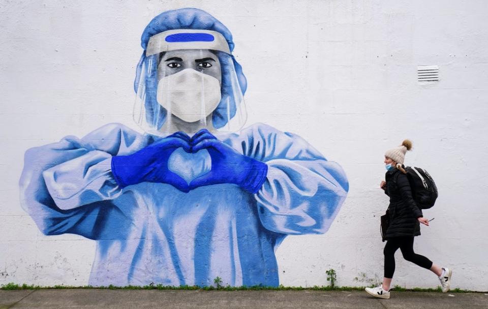 A woman passes a mural of a frontline worker in Dublin. (Brian Lawless/PA) (PA Wire)