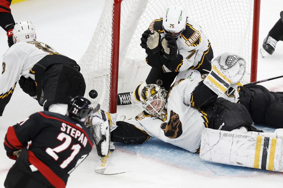 Boston Bruins' Connor Clifton (75) falls on his goalie Linus Ullmark during a scramble in the third period of an NHL hockey game against the Carolina Hurricanes, Friday, Nov. 25, 2022, in Boston. Ullmark left the game after the play with an undisclosed injury. (AP Photo/Michael Dwyer)