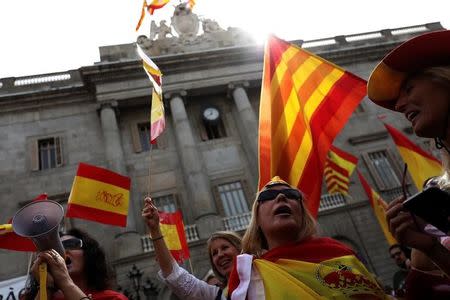 People hold up Spanish and Catalan flags during a demonstration in favor of a unified Spain a day before the banned October 1 independence referendum, in Barcelona, Spain, September 30, 2017. REUTERS/Susana Vera