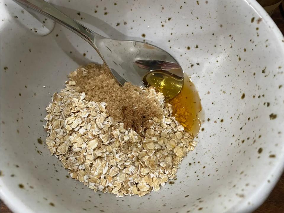 Oats, honey, and sugar in a bowl.