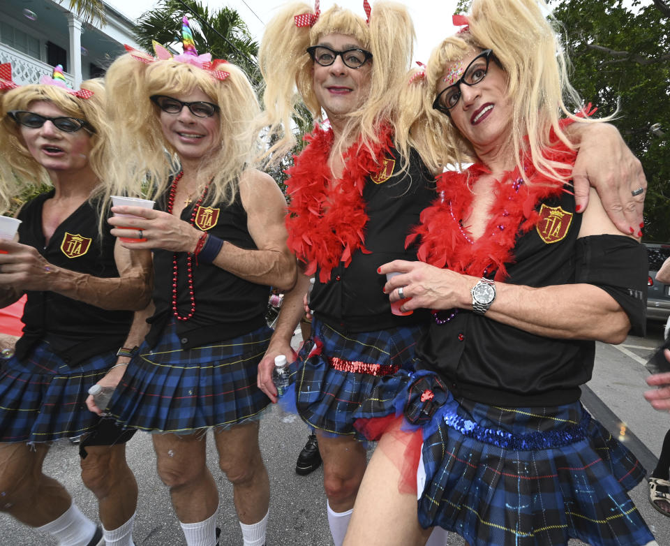 In this Friday, Oct. 27, 2023, photo provided by the Florida Keys News Bureau, four men costumed as pigtailed and uniformed schoolgirls bring their hijinks to the Fantasy Fest Masquerade March in Key West, Fla. The procession was a highlight of the island city's 10-day Fantasy Fest costuming and masking celebration that continues through Sunday, Oct. 29. The festival's 2023 theme is "Uniforms and Unicorns … 200 Years of Sailing into Fantasy," chosen to salute the Florida Keys' bicentennial and that of the U.S. Navy in Key West. (Andy Newman/Florida Keys News Bureau via AP)