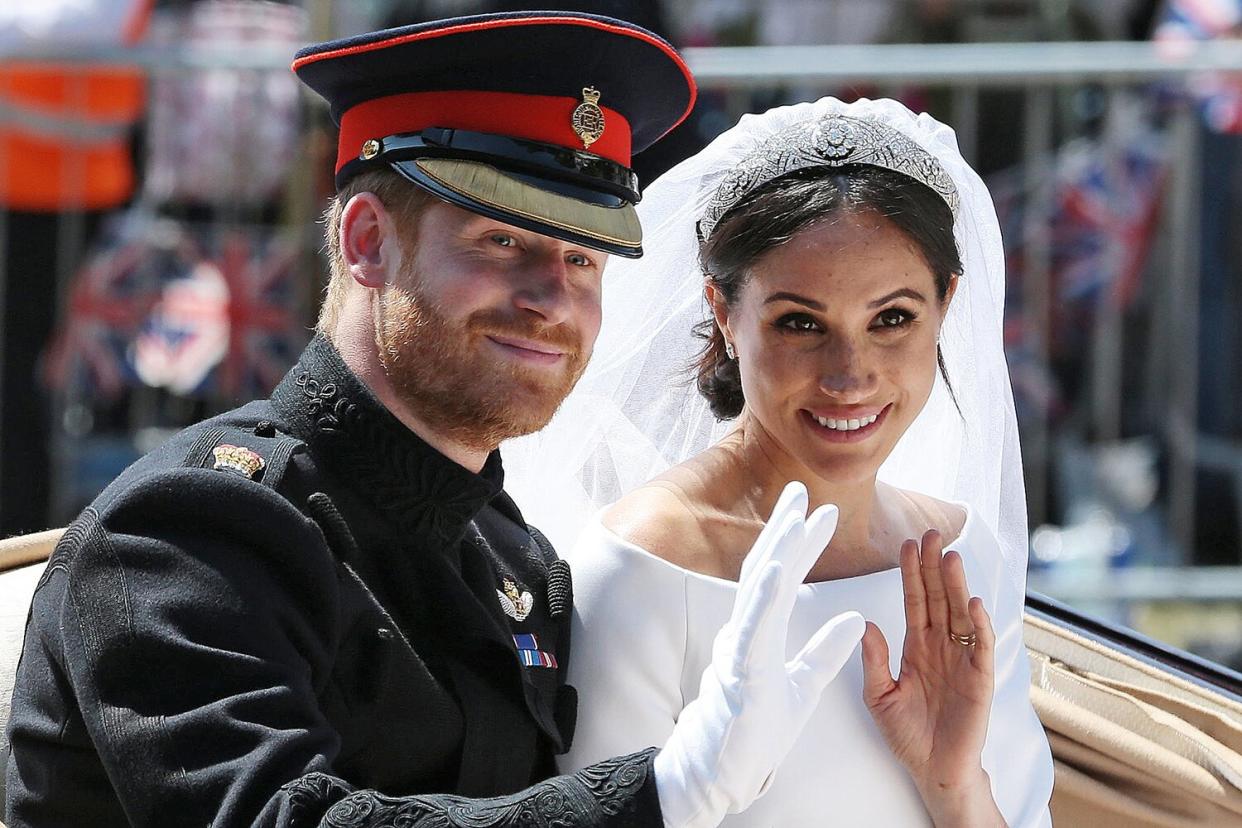 Britain's Prince Harry, Duke of Sussex and his wife Meghan, Duchess of Sussex wave from the Ascot Landau Carriage during their carriage procession on the Long Walk as they head back towards Windsor Castle in Windsor, on May 19, 2018 after their wedding ceremony.