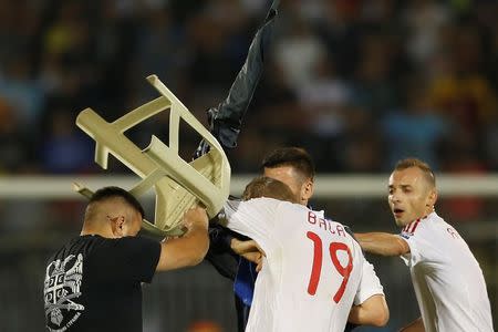 A fan of Serbia scuffles with Bekim Balaj (C) of Albania next to his teammate Ansi Agolli (R) and Nenad Tomovic of Serbia during their Euro 2016 Group I qualifying soccer match at the FK Partizan stadium in Belgrade October 14, 2014. REUTERS/Marko Djurica