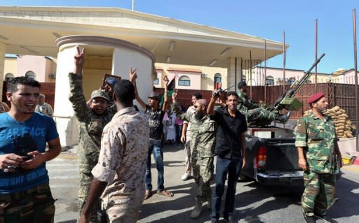 Libyan soldiers gather outside the Abu Salim prison in Tripoli to celebrate following extradition of Abdullah al-Senussi, fallen dictator Moamer Kadhafi's former spy chief, to Libya by Mauritania. Senussi could be held accountable for the Abu Salim prison 1996 massacre when more than 1,000 detainees were executed