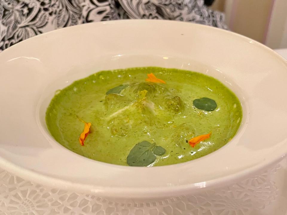 Bowl of escargot and green sauce.