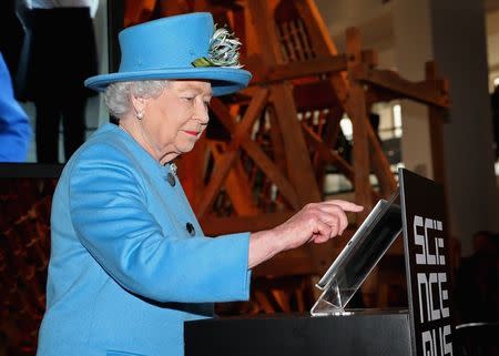 Britain's Queen Elizabeth presses a button to send her first Tweet during a visit to the 'Information Age' Exhibition at the Science Museum, in London October 24, 2014. REUTERS/Chris Jackson/Pool