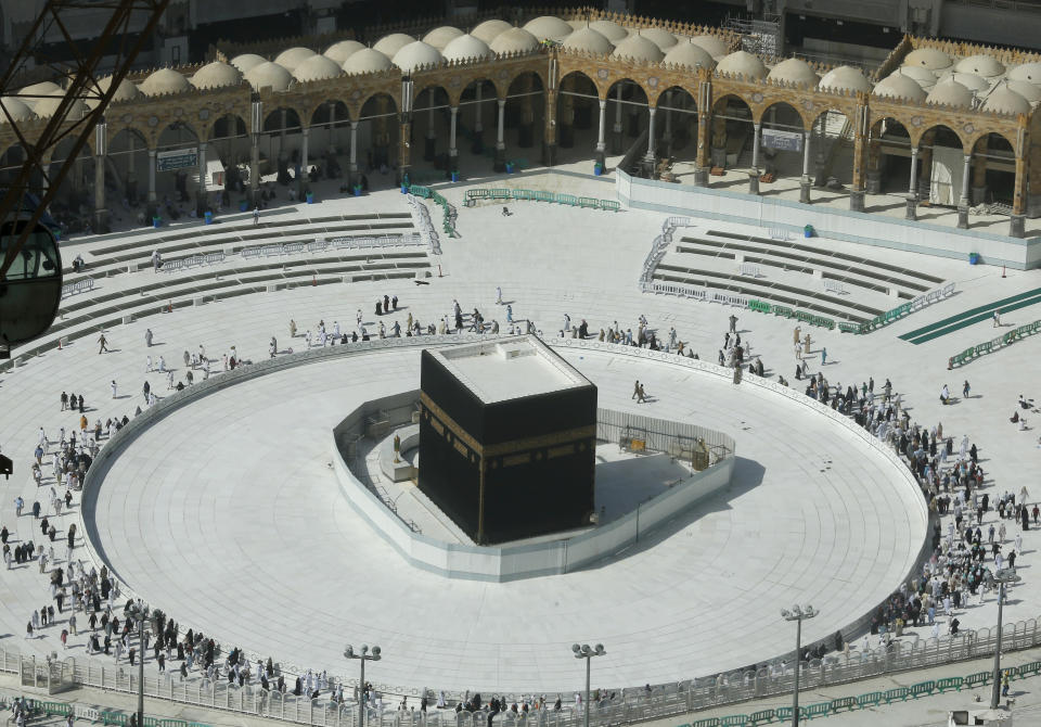 Muslims circumambulate the Kaaba, the cubic building at the Grand Mosque, in the Muslim holy city of Mecca, Saudi Arabia, Saturday, March 7, 2020. Few worshippers were allowed to enter after dawn prayers to circumambulate the Kaaba over fears of coronavirus. (AP Photo/Amr Nabil)