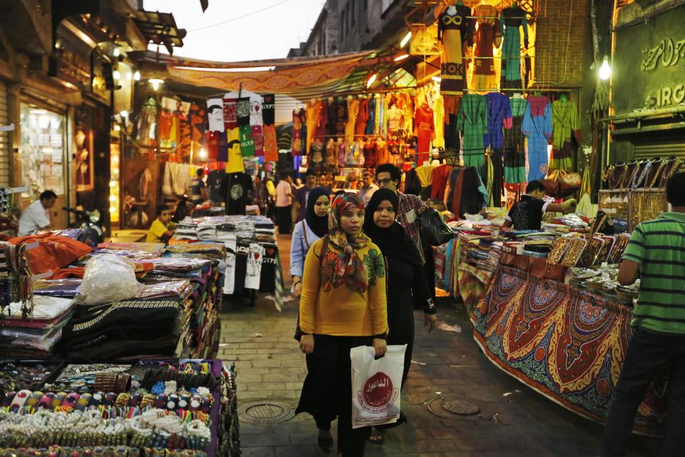 Egyptians walk in the Khan El-Khalili market, normally a popular tourist destination, in Cairo, Egypt, Monday, Sept. 9, 2013. Before the 2011 revolution that started Egypt's political roller coaster, sites like the pyramids were often overcrowded with visitors and vendors, but after a summer of coup, protests and massacres, most tourist attractions are virtually deserted to the point of being serene. (AP Photo/Lefteris Pitarakis)