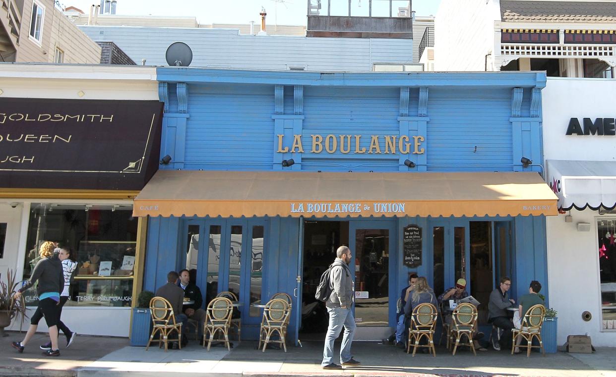 La Boulange in San Francisco circa 2012. Pedestrians walk by the blue building.