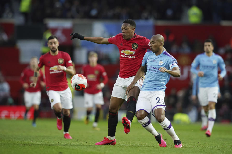 Manchester United's Anthony Martial, center, and Manchester City's Fernandinho compete for the ball during the English Premier League soccer match between Manchester United and Manchester City at Old Trafford in Manchester, England, Sunday, March 8, 2020. (AP Photo/Dave Thompson)