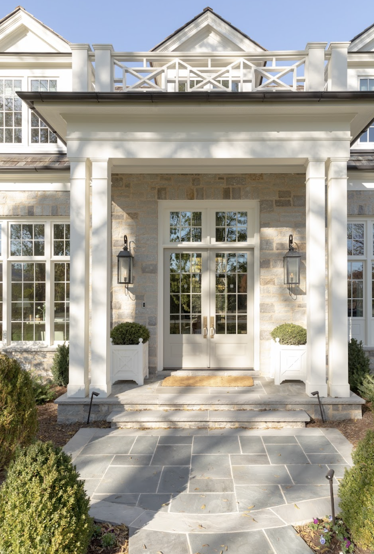 a white house with a large front door and a stone patio