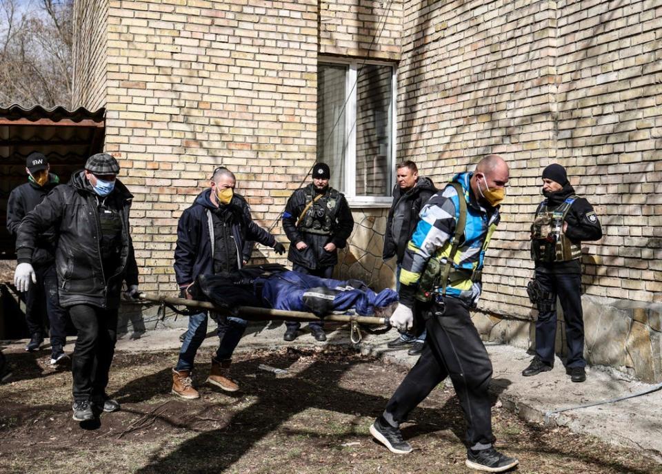 A body is carried at a school in Bucha (AFP/Getty)