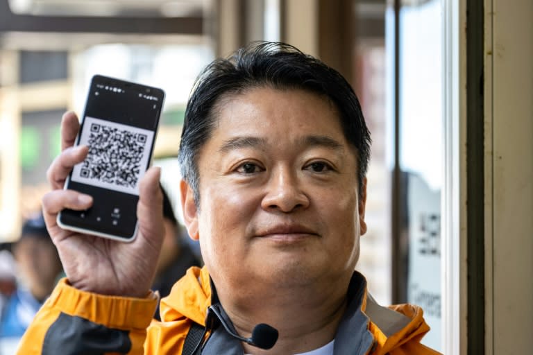 Le gouverneur de la préfecture de Yamanashi, Kotaro Nagasaki, présente un QR code et les nouvelles procédures de paiement d'entrée pour gravir le mont Fuji, le 19 juin 2024 (Philip FONG)