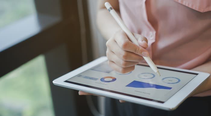 Close up on businesswoman's hand using stylus pen for writing on tablet screen