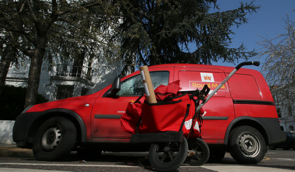 A Royal Mail van is parked by a post trolley ready to deliver the days mail in London, Tuesday, April, 1, 2014. The British government cost taxpayers millions by selling off the Royal Mail at too low a price, the country's public-spending watchdog said Tuesday. The Conservative-led government sold a majority stake in the postal service last year, putting the system under private control for the first time in its 500-year history. (AP Photo/Alastair Grant)