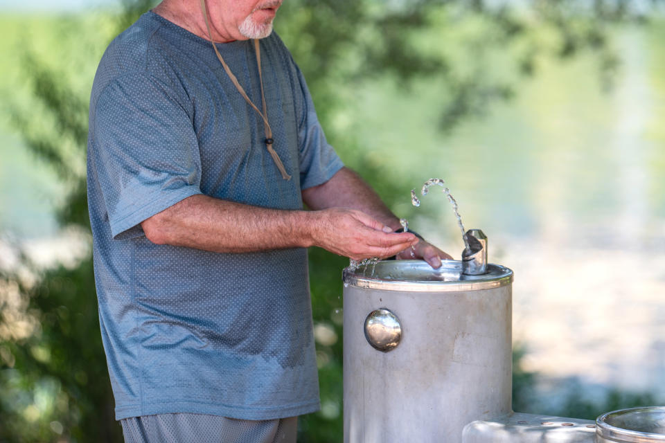 A resident tests the temperature of drinking fountain water during a heatwave in Austin, Texas, US, on Wednesday, July 12, 2023. A record-breaking heat wave is about to send temperatures soaring from California to the Gulf of Mexico, posing health risks and straining power grids for days to come. (Sergio Flores / Bloomberg via Getty Images)