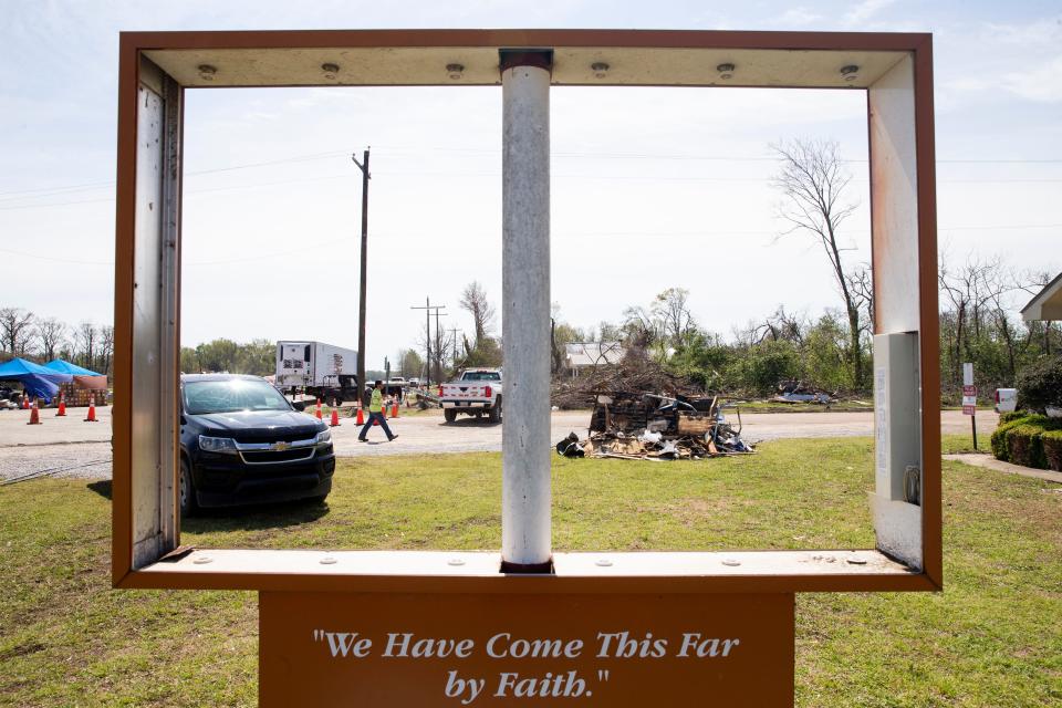 A damaged sign for Little Mount Zion Missionary Baptist Church with the words “we have come this far by faith” can be seen as recovery efforts continue behind it in Silver City on Tuesday. An EF-4 tornado damaged parts of Silver City and killed at least two residents on Friday night. The church is being used as overflow storage for clothes and other supplies collected by the community that residents may need.