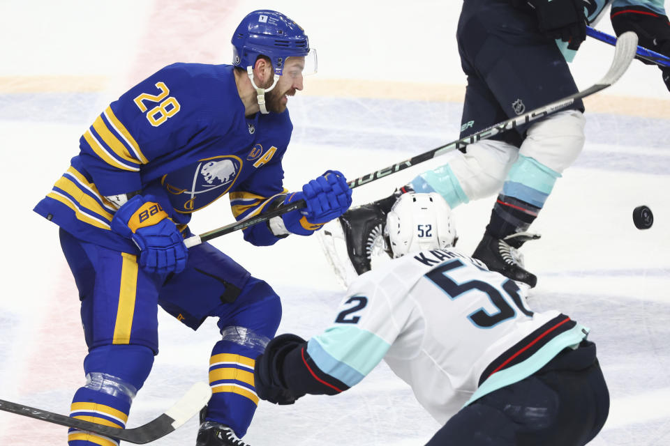 Buffalo Sabres left wing Zemgus Girgensons (28) pushes the puck past Seattle Kraken left wing Tye Kartye (52) during the third period of an NHL hockey game Tuesday, Jan. 9, 2024, in Buffalo, N.Y. (AP Photo/Jeffrey T. Barnes)