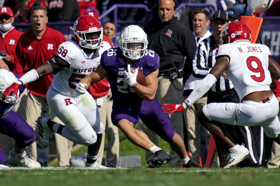 Northwestern running back Evan Hull, center, runs with the ball against Rutgers linebacker Mohamed Toure, left, and linebacker Tyreek Maddox-Williams during the first half of an NCAA college football game in Evanston, Ill., Saturday, Oct. 16, 2021. (AP Photo/Nam Y. Huh)