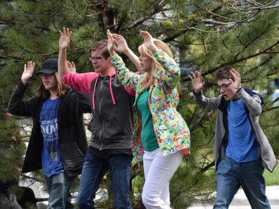 Students and teachers raise their arms as they flee a shooting at Stem School Highlands Ranch near Denver (Getty Images)