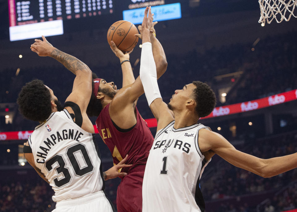 San Antonio Spurs' Victor Wembanyama (1) and Julian Champagnie (30) block Cleveland Cavaliers' Jarrett Allen (31) during the first half of an NBA basketball game in Cleveland, Sunday, Jan. 7, 2024. (AP Photo/Phil Long)