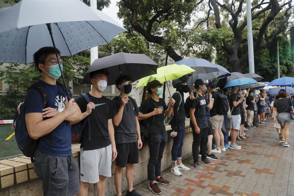 Current and former students from a secondary school stand outside their school for protests at Central in Hong Kong, on Monday, Sept. 2, 2019. Hong Kong has been the scene of tense anti-government protests for nearly three months. The demonstrations began in response to a proposed extradition law and have expanded to include other grievances and demands for democracy in the semiautonomous Chinese territory. (AP Photo/Kin Cheung)