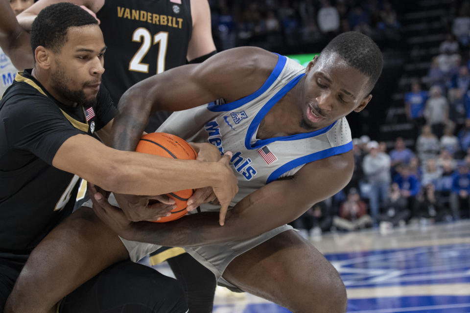 Vanderbilt guard Isaiah West, left, and Memphis forward David Jones, right, wrestle for the ball during the second half of an NCAA college basketball game Saturday, Dec. 23, 2023, in Memphis, Tenn. (AP Photo/Nikki Boertman)