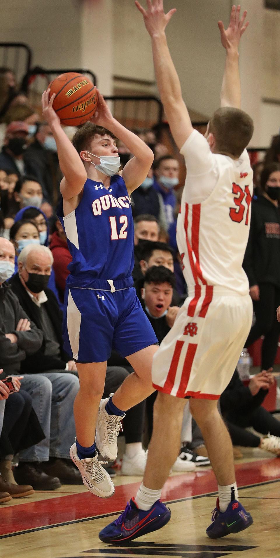 Quincy's Jimmy Phipps, left, tries to pass over North Quincy's Zach Taylor. North Quincy hosted Quincy in boys basketball on Friday, Jan. 21, 2022.