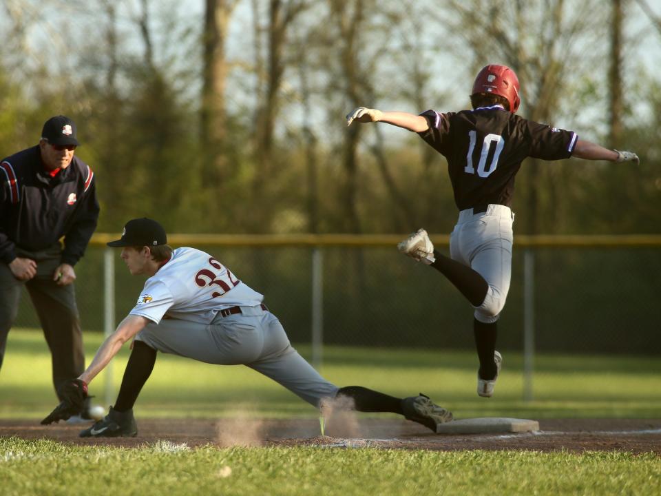 Granville Christian's Josiah Green leaps to first base as Liberty Christian's James Rainier reaches for the throw on Thursday.