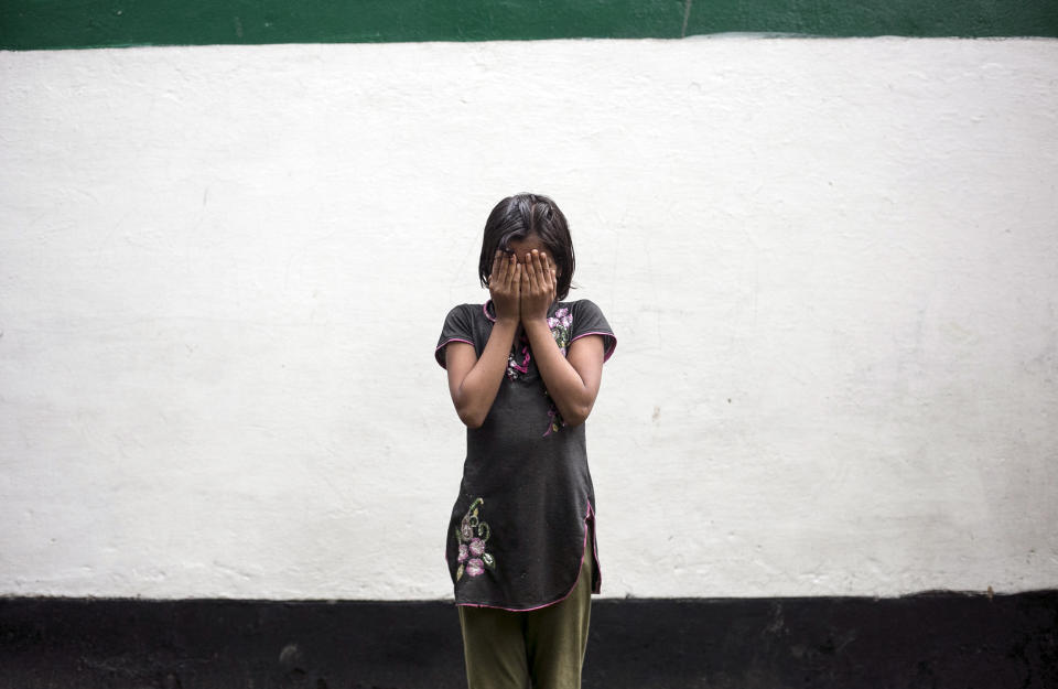 UTTAR PRADESH, INDIA - AUGUST 1:  9 year old Gitanjali (name changed) poses for a photo on August 1, 2016 in Uttar Pradesh, India. Her 30 year old father sexually abused her for years and raped her last year. He threatened to beat her and her mother with metal rods if she told anyone. When her grandfather found out, he went to the police and had him arrested. Since then, the whole family and whole village has been pressuring him to drop the case. He says 'Everyone in the village is against me. They say that he's my only son and ask who will look after me and my family? They don't understand that what he did is very wrong. They don't think that it's true. Even my wife and Gitanjali's mother want me to drop the case. I don't know how much longer I can go on, but I know who he is, I know he will never change. If I drop the case it will give him the strength to do this again.'  Their neighbors and people in the village tease and taunt Gitanjali and ask 'what will happen to your future?', 'who will marry you now?' and 'what will happen to your mother?'. They tell her to stop lying. Gitanjali's mother says that even though her husband often beat her, she wants him to get out of jail and come home. 'If he gets out he will promise to stop abusing Gitanjali. It's her fault as well. When she would be sick she would stay in bed, she would run around and act childish and my husband would watch her. I told her to stay away from him. She should have shouted when he locked the door. She didn't share anything with me.' She says that her husband would often make her sleep on the floor while he slept in the bed with Gitanjali. Gitanjali says that she feels sad that her father is in jail. She says that when he's around that financially things are better, that he looks after the family and is able to buy them things. She says that everyday her mother calls her a prostitute and blames her for her father being gone. (Photo by Getty Images)