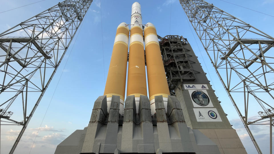 A three-booster orange and white Delta IV Heavy rocket stands on the launch pad for its final flight at Florida's Cape Canaveral Space Force Station.