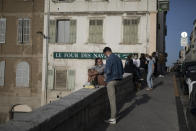 Residents gather for drinks outdoors before curfew in Marseille, southern France, Friday, April 2, 2021. With France now Europe's latest virus danger zone, Macron on Wednesday ordered temporary school closures nationwide and new travel restrictions. But he resisted calls for a strict lockdown, instead sticking to his "third way" strategy that seeks a route between freedom and confinement to keep both infections and a restless populace under control until mass vaccinations take over. (AP Photo/Daniel Cole)