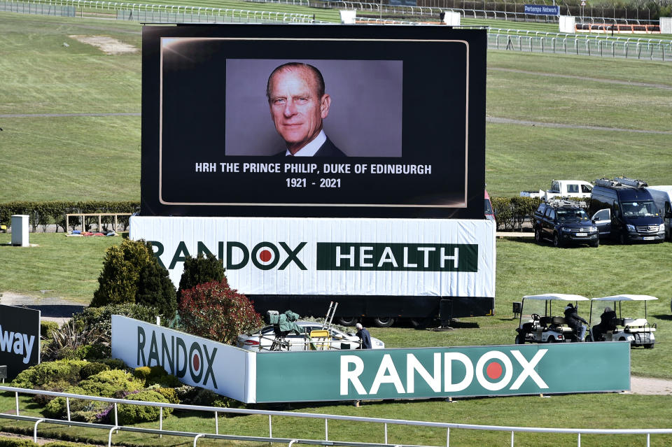 A video screen shows a picture of the late Prince Philip, Duke of Edinburgh, ahead of the races on the second day of the Grand National Horse Racing meeting at Aintree racecourse, near Liverpool, England, Friday April 9, 2021. Buckingham Palace says Prince Philip, the irascible and tough-minded husband of Queen Elizabeth II, has died. He was 99. (Peter Powell/Pool via AP)