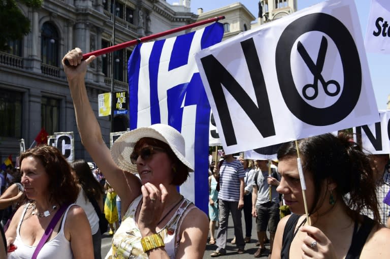 A woman holds a placard reading "No cuts" during a demonstration in support of Greece, in Madrid on July 5, 2015