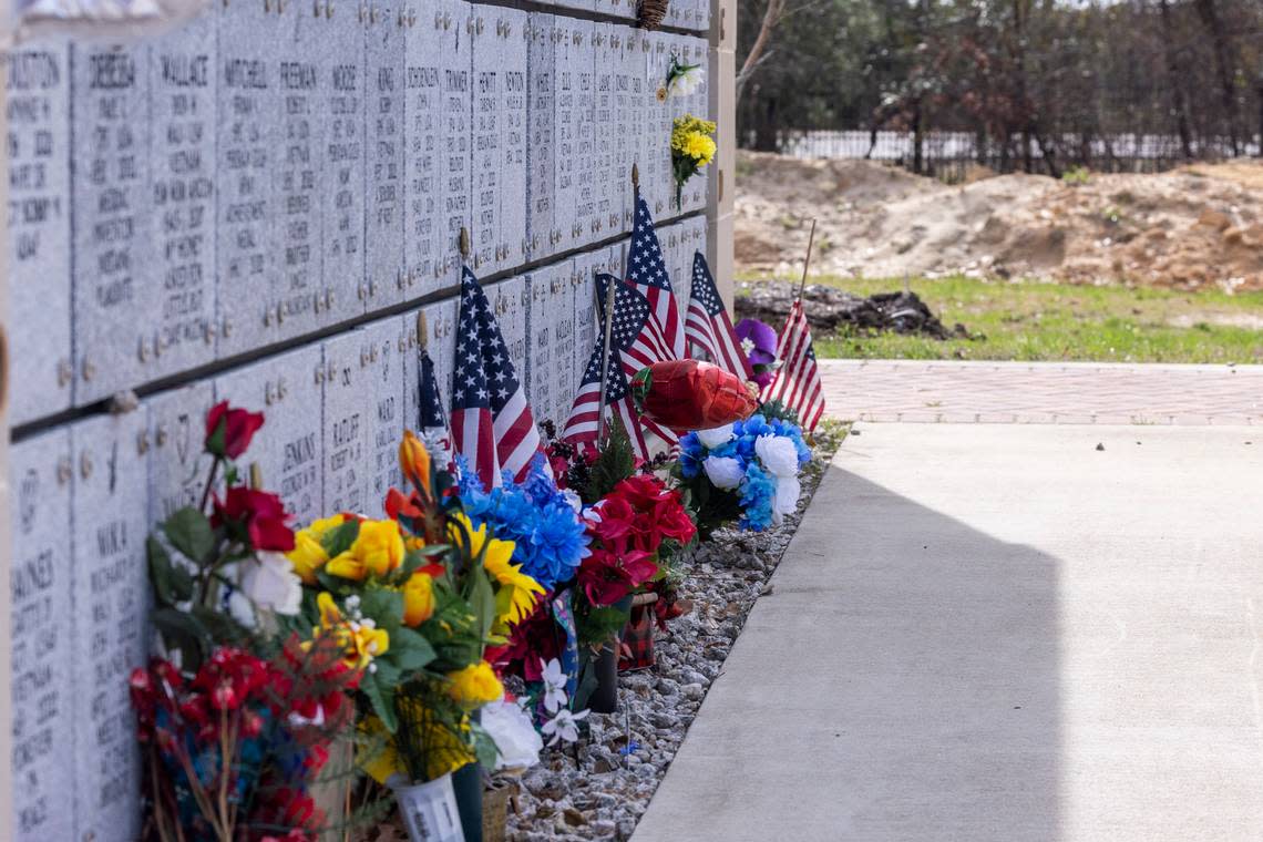 Flowers and flags line the base of a mausoleum at Sandhills State Veterans Cemetery in Spring Lake Tuesday, Feb 21, 2022. North Carolina’s four state-owned veterans cemeteries are behind on maintenance and are short-staffed
